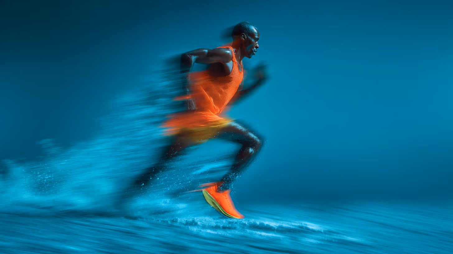 Athlete in orange running at high speed with motion blur and water splashing.
