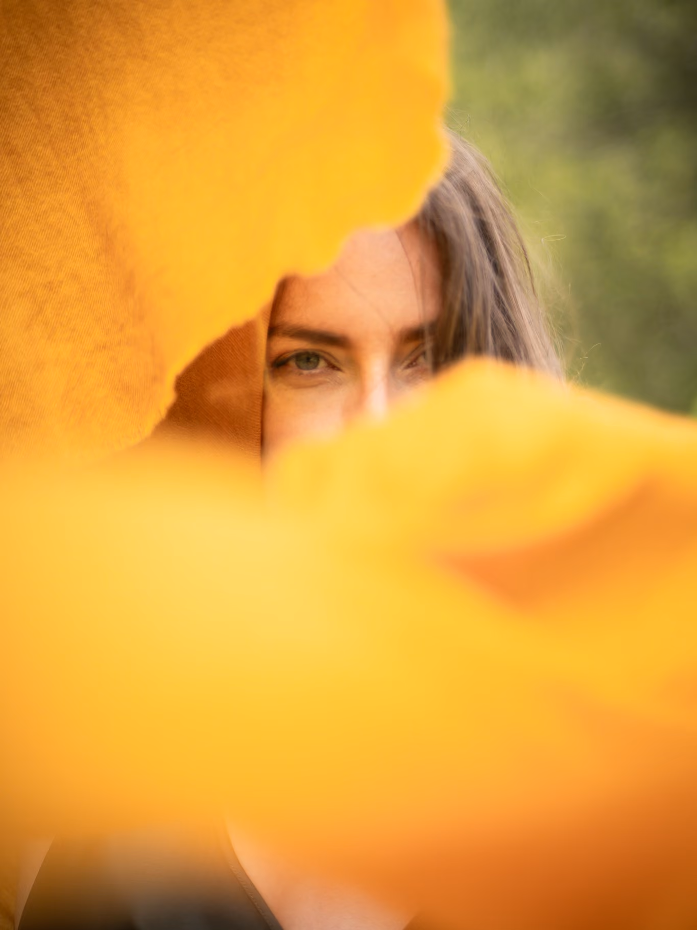 MARICI campaign portrait, a woman framed by soft yellow cashmere fabric