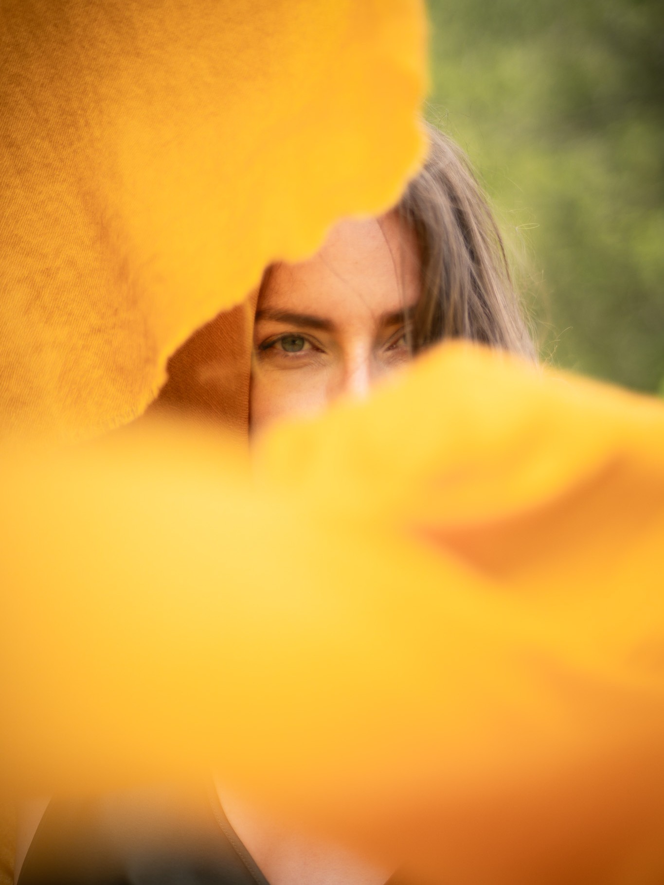 MARICI campaign portrait, a woman framed by soft yellow cashmere fabric