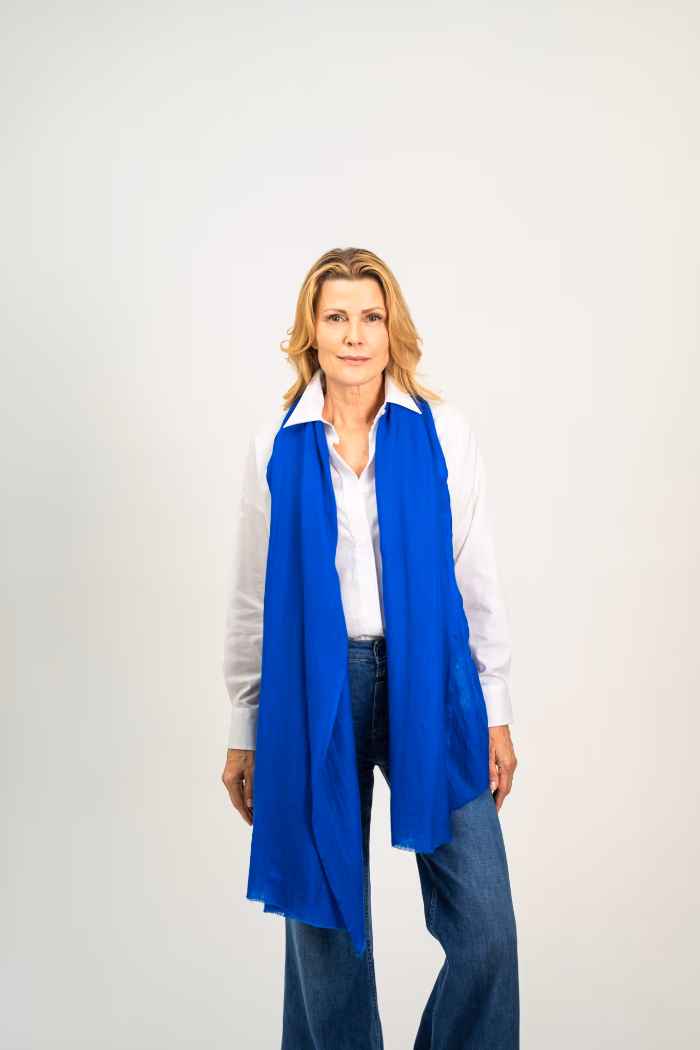 Model trägt kobaltblauen Mantel mit Seidenschal – Marici Fashion München