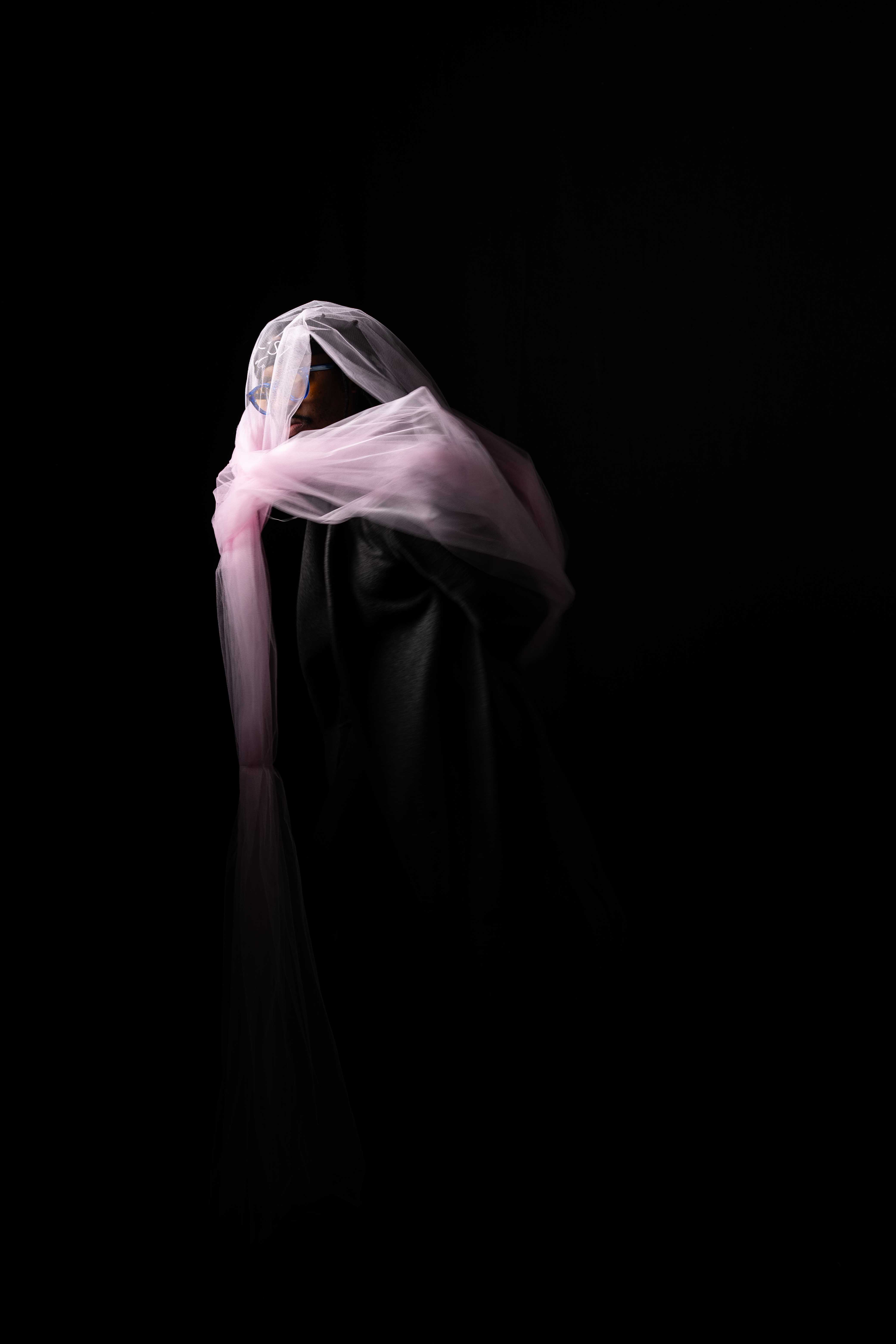 Tim by FADETOBLACK, studio portrait photography, image 19: Low-key studio portraits of a man against a black background, wrapped in flowing pink tulle