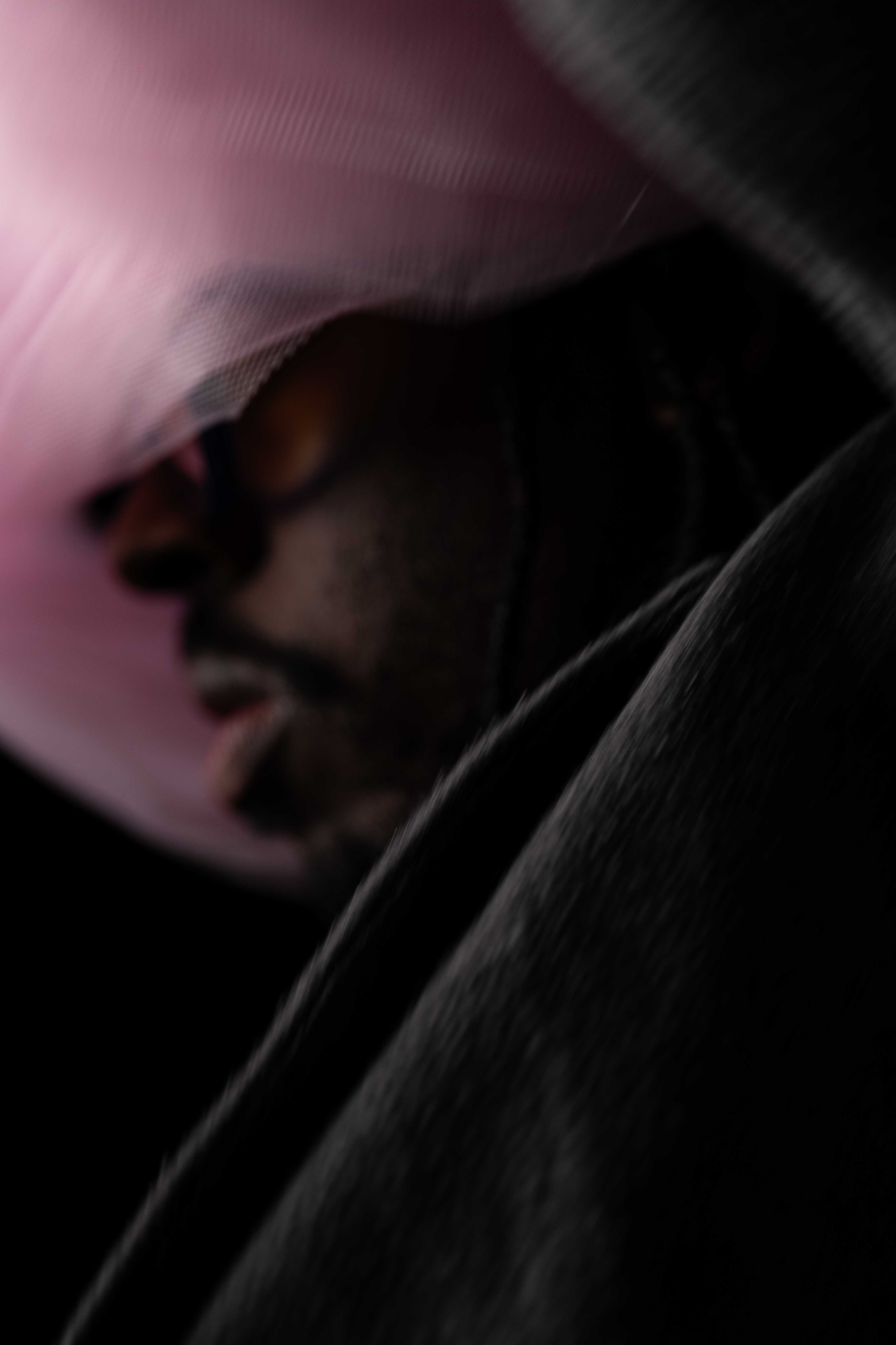 Tim by FADETOBLACK, studio portrait photography, image 7: Low-key studio portraits of a man against a black background, wrapped in flowing pink tulle