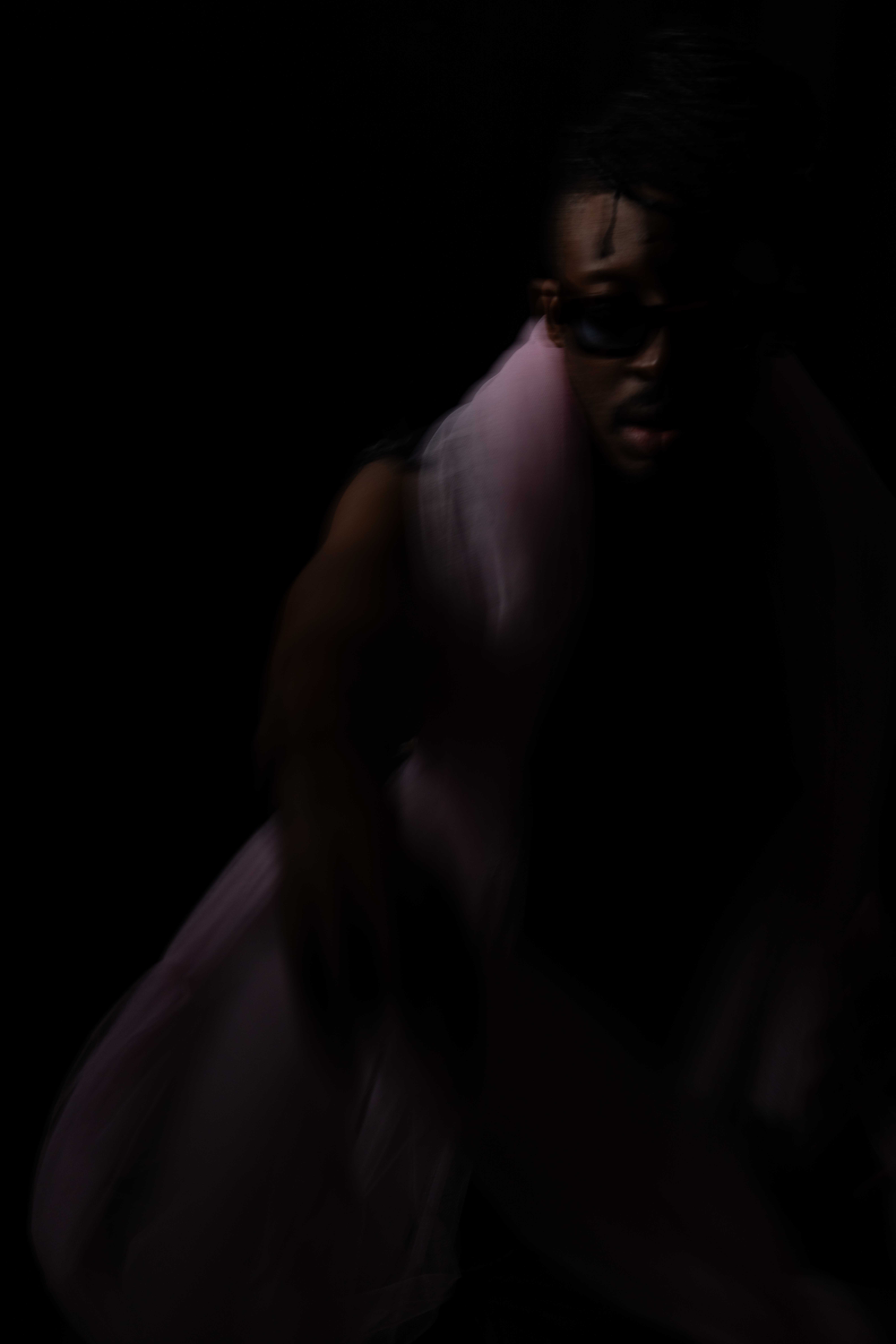 Tim by FADETOBLACK, studio portrait photography, image 12: Low-key studio portraits of a man against a black background, wrapped in flowing pink tulle