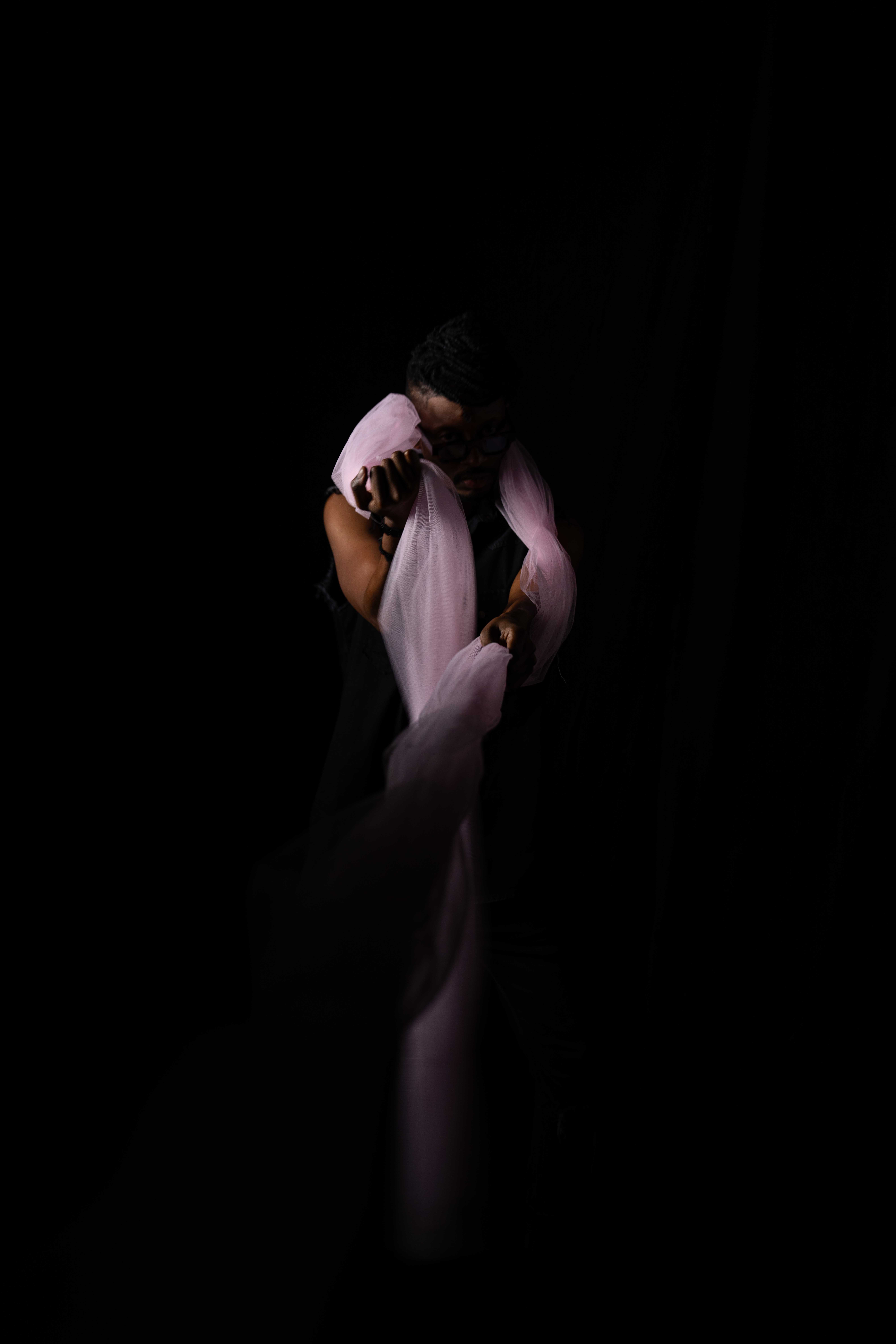 Tim by FADETOBLACK, studio portrait photography, image 11: Low-key studio portraits of a man against a black background, wrapped in flowing pink tulle