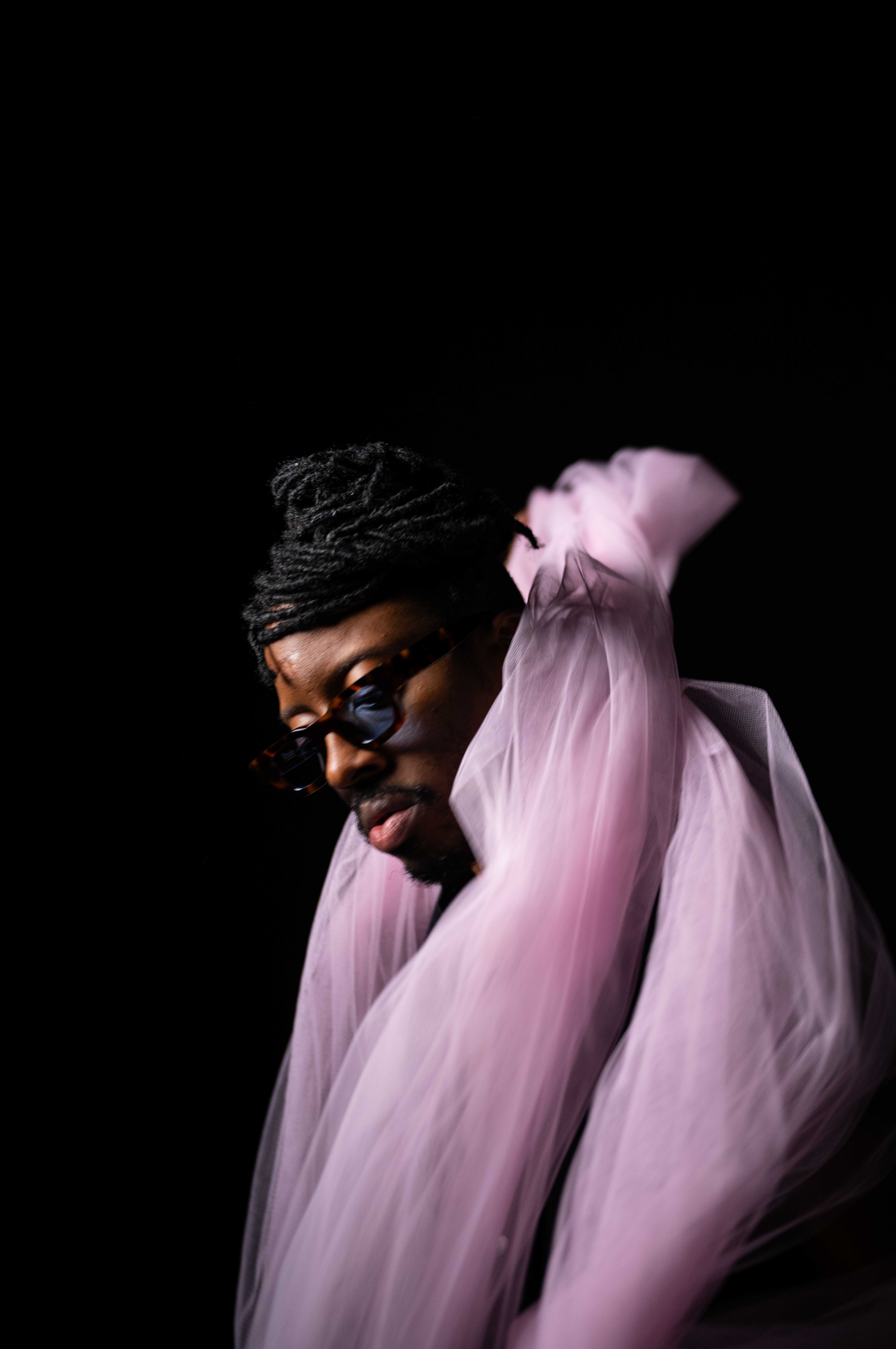 Tim by FADETOBLACK, studio portrait photography, image 23: Low-key studio portraits of a man against a black background, wrapped in flowing pink tulle