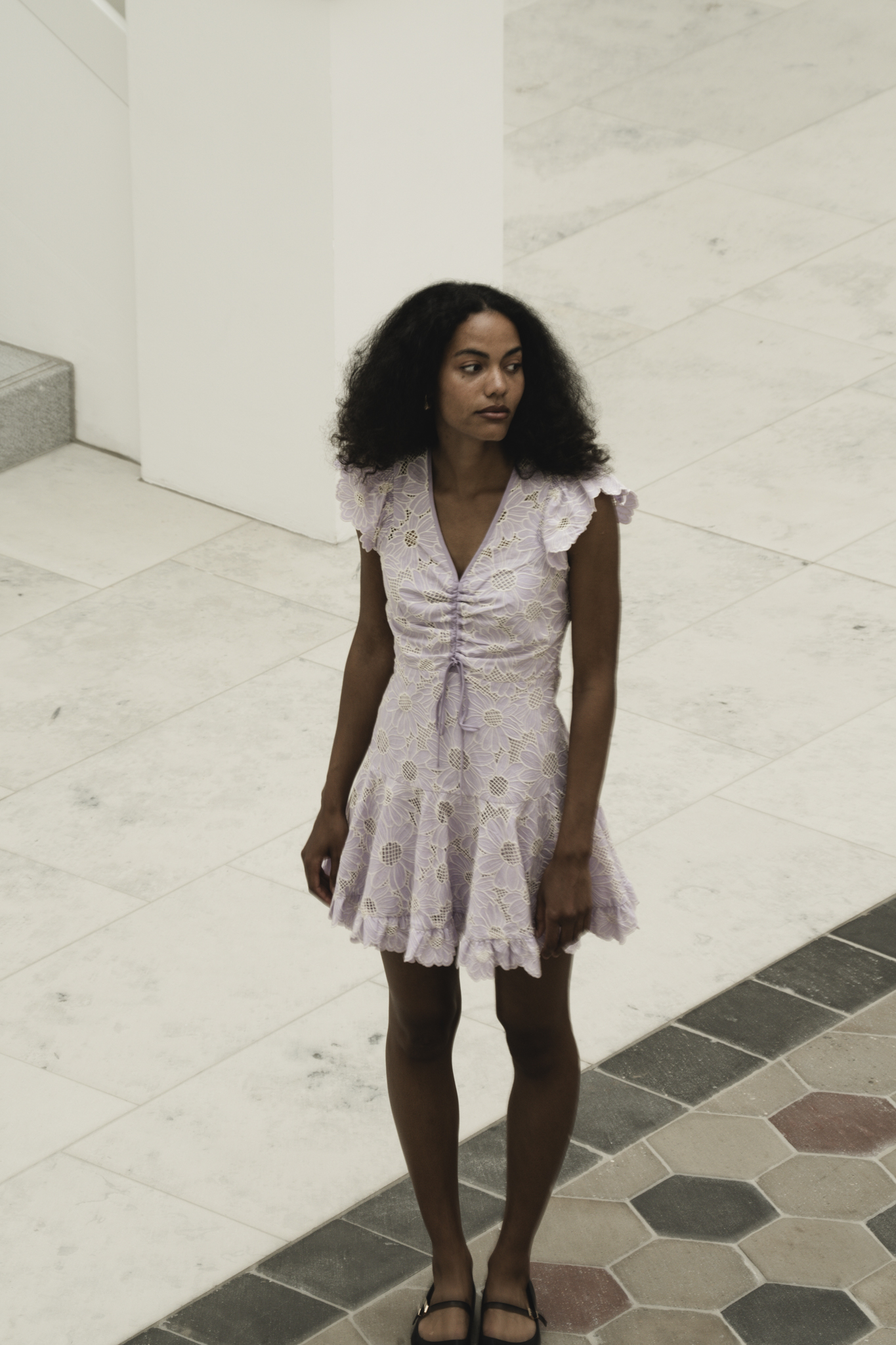 A Dance of Contradictions by FADETOBLACK, fine art portrait photography, image 16: Portraits of a woman with voluminous curly hair in a short ruffled lilac lace dress, moving between bright