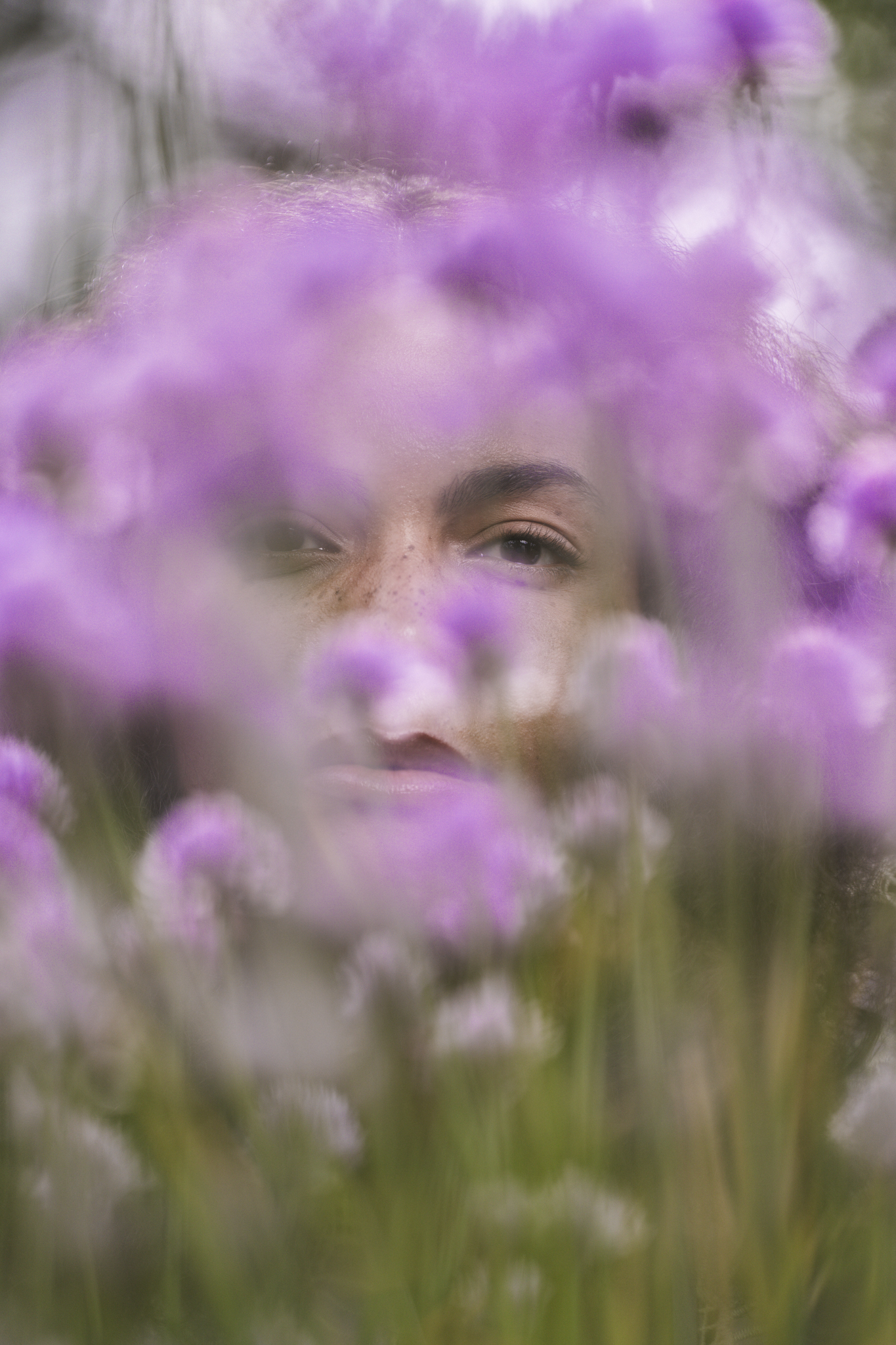 A Dance of Contradictions by FADETOBLACK, fine art portrait photography, image 14: Portraits of a woman with voluminous curly hair in a short ruffled lilac lace dress, moving between bright