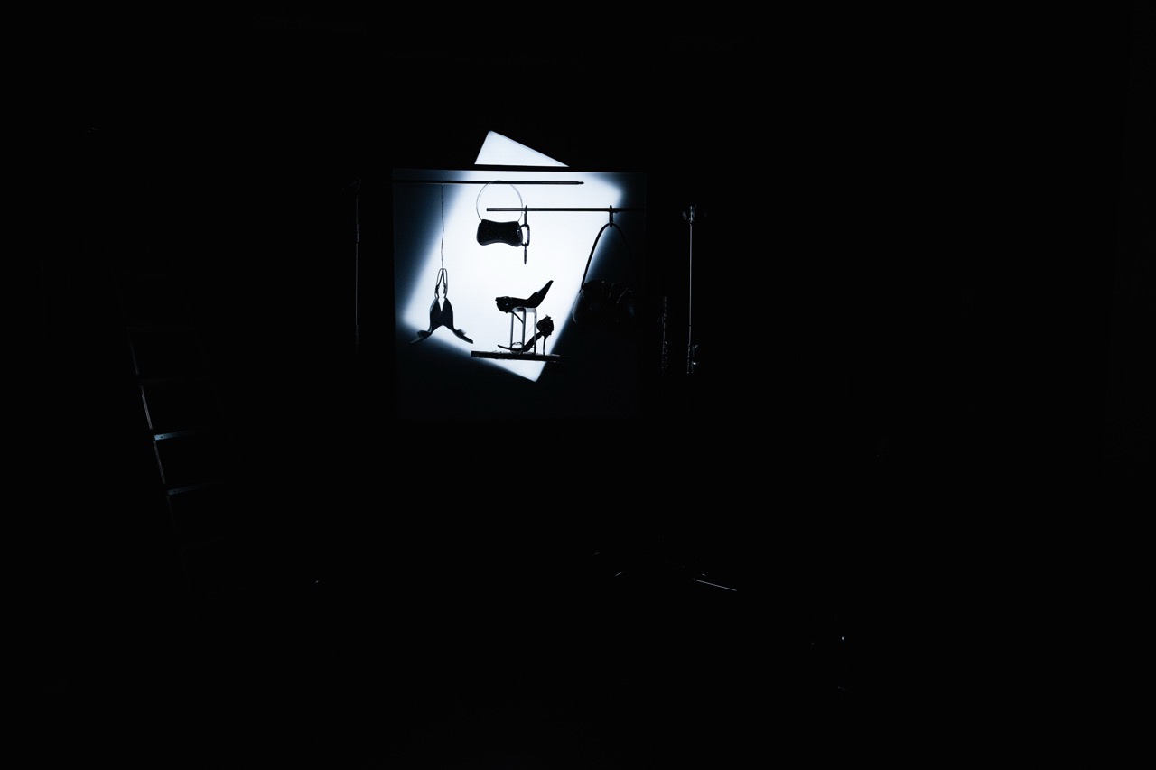 DIESEL x DUST MAGAZINE by FADETOBLACK, still life campaign photography, image 6: High-contrast, near-monochrome still life series shot in a dark studio: fashion accessories such as heeled
