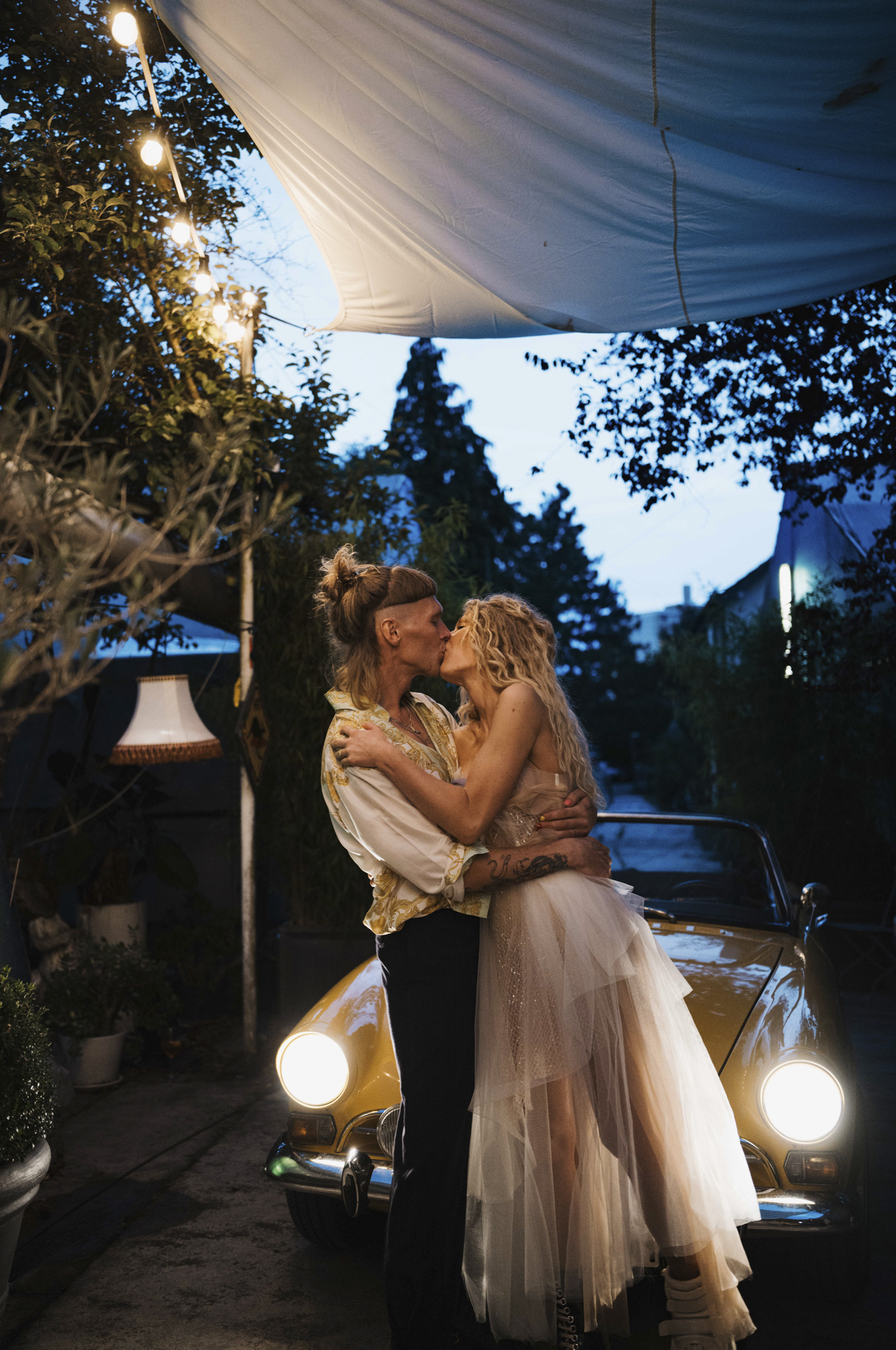 Eternal Moments: A Wedding Photography Collection by FADETOBLACK, wedding photography, image 10: Wedding series mixing black and white and color: a bride in a lace puff-sleeve dress beside a vintage car