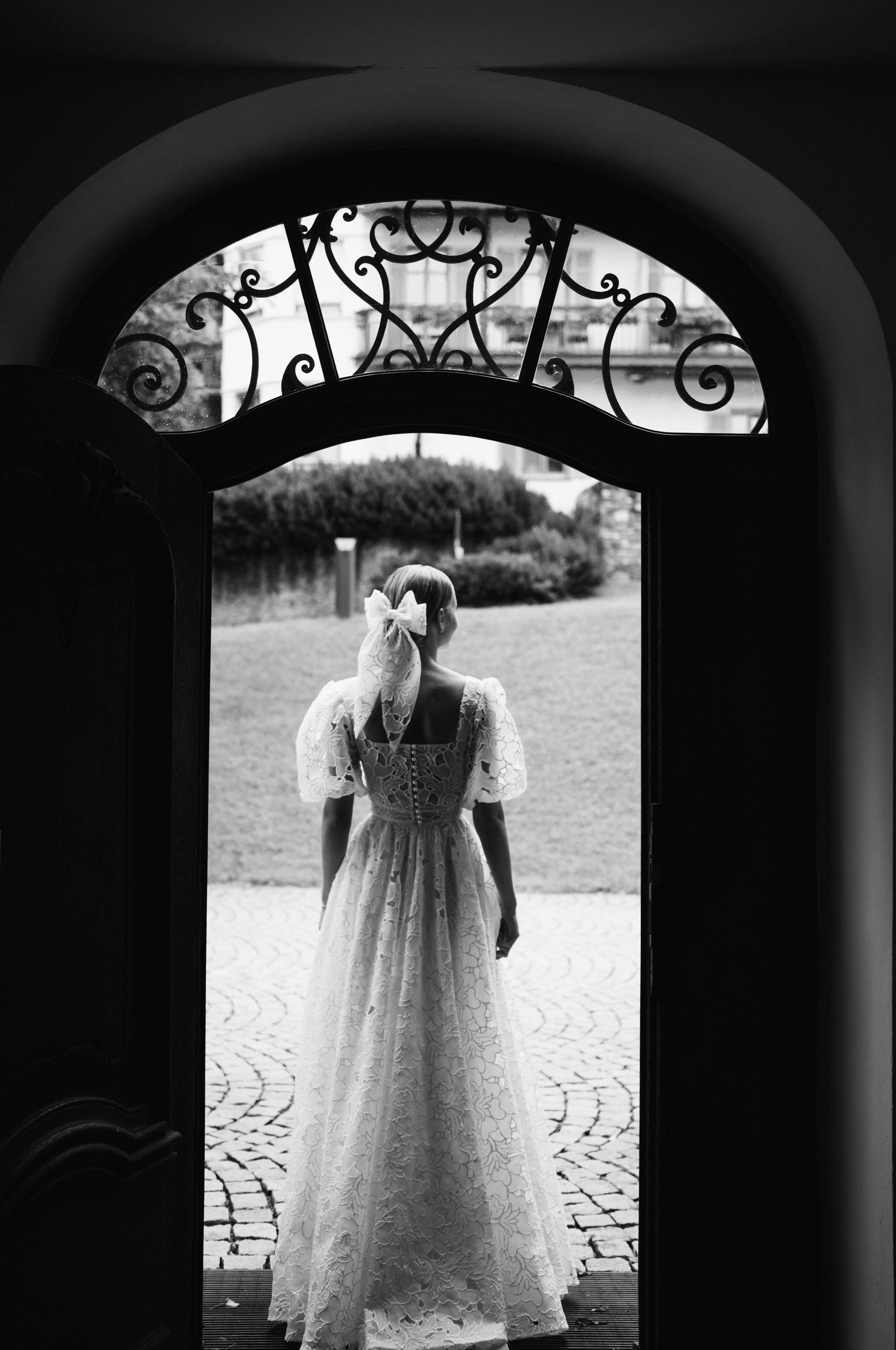 Eternal Moments: A Wedding Photography Collection by FADETOBLACK, wedding photography, image 6: Wedding series mixing black and white and color: a bride in a lace puff-sleeve dress beside a vintage car