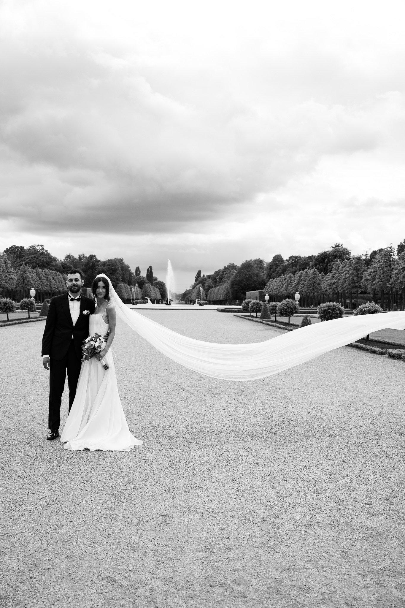 Eternal Moments: A Wedding Photography Collection by FADETOBLACK, wedding photography, image 28: Wedding series mixing black and white and color: a bride in a lace puff-sleeve dress beside a vintage car