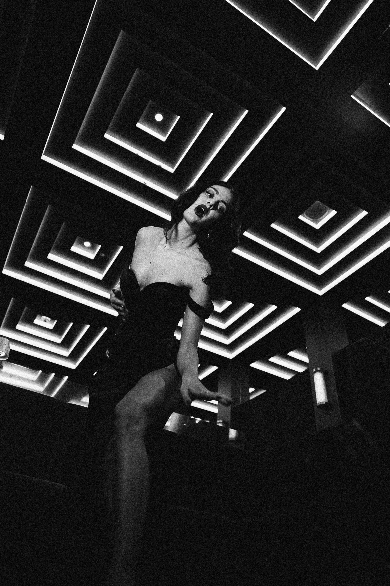 Heartless by FADETOBLACK, editorial fashion photography, image 19: Nighttime hotel editorial with two models in metallic gold and black mini dresses and thigh-high boots,