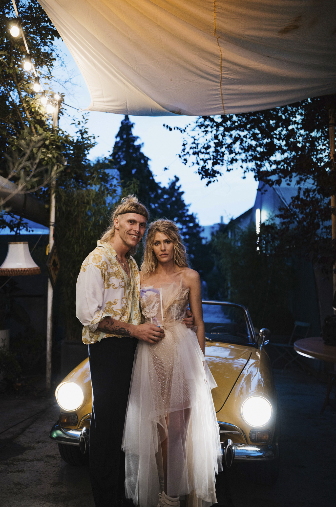 Eternal Moments: A Wedding Photography Collection by FADETOBLACK, wedding photography, image 32: Wedding series mixing black and white and color: a bride in a lace puff-sleeve dress beside a vintage car