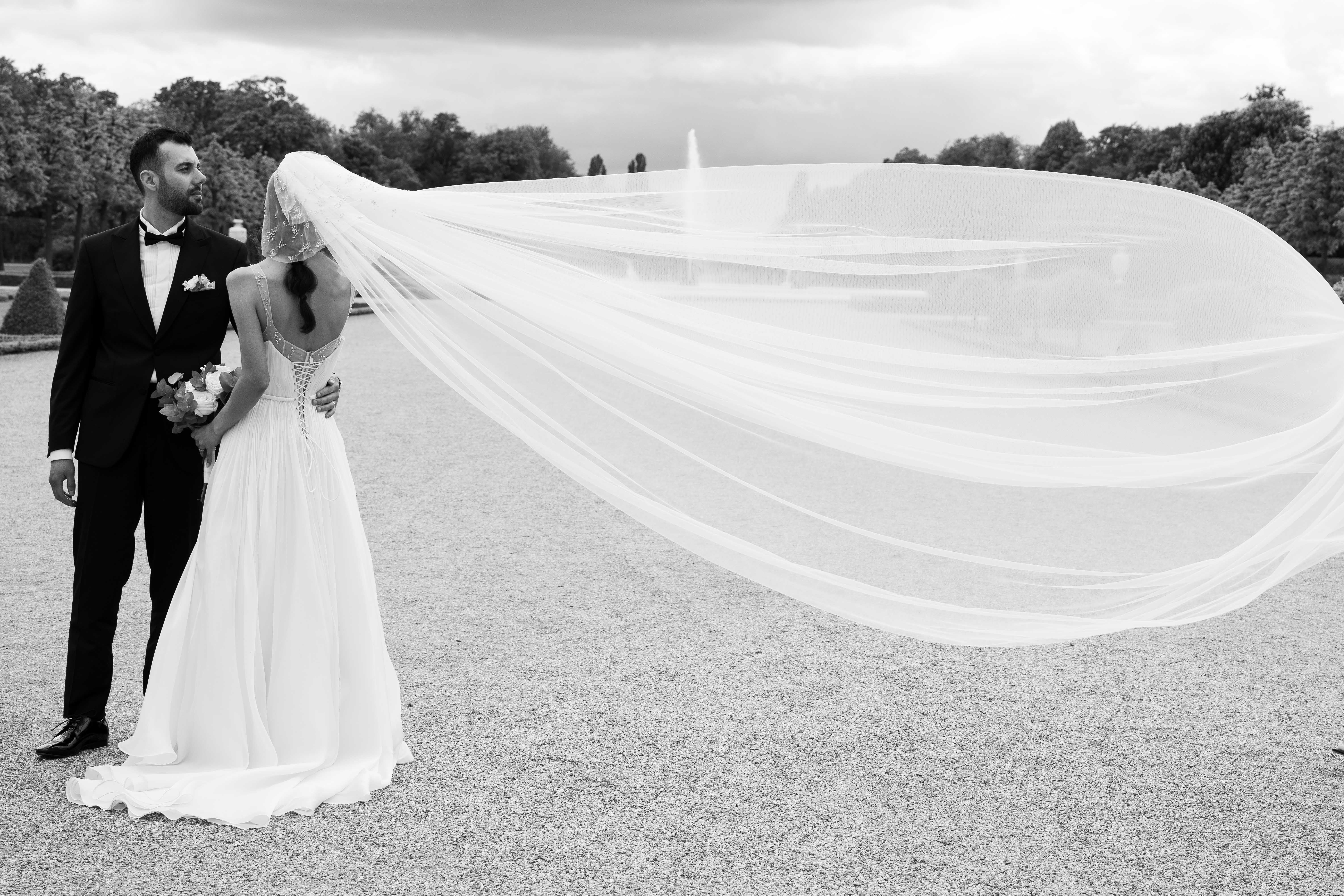 Eternal Moments: A Wedding Photography Collection by FADETOBLACK, wedding photography, image 34: Wedding series mixing black and white and color: a bride in a lace puff-sleeve dress beside a vintage car