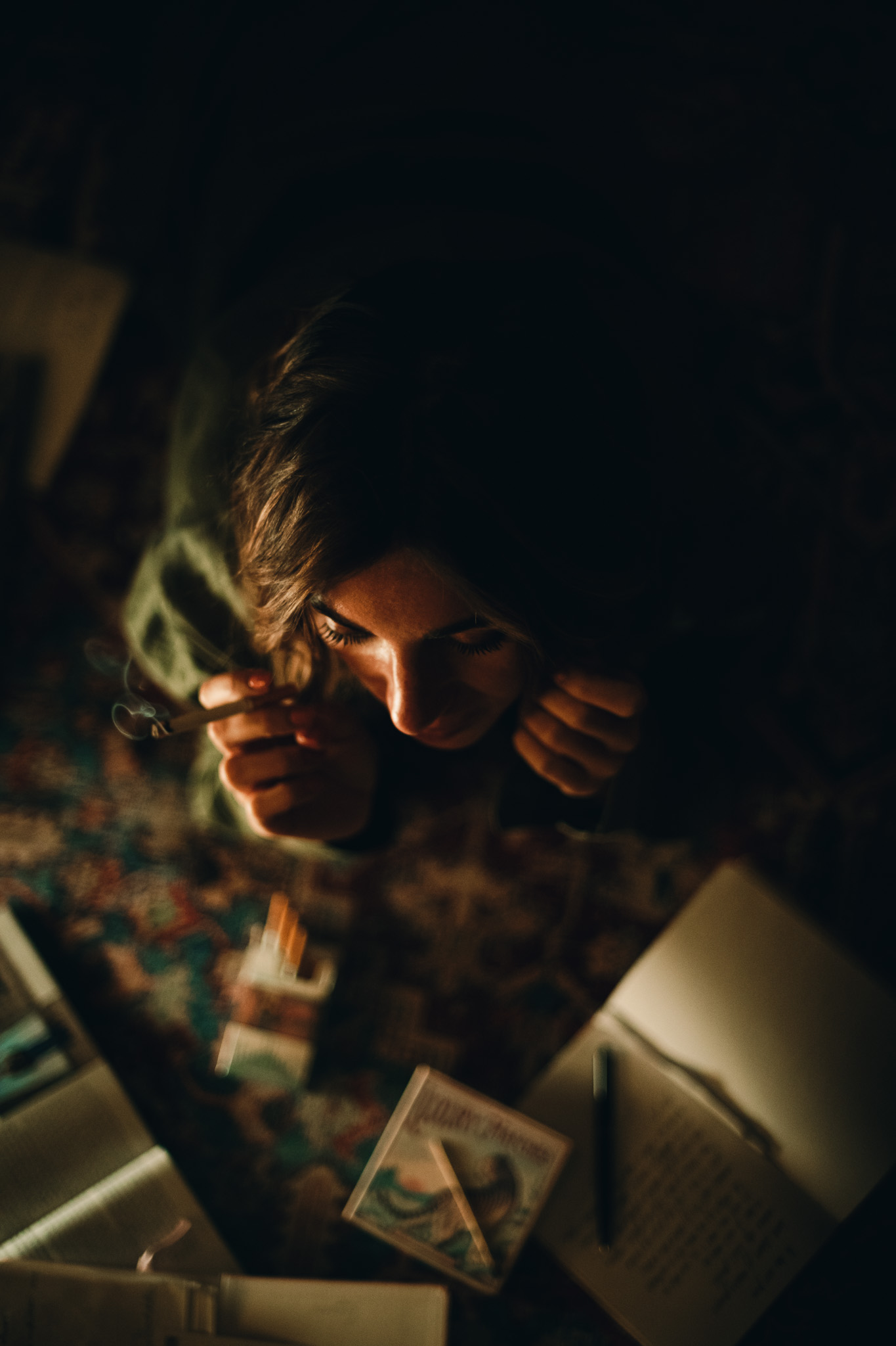Chiara by FADETOBLACK, portrait photography, image 7: Cinematic low-light portraits of a woman in warm interiors: lying on an oriental rug surrounded by a