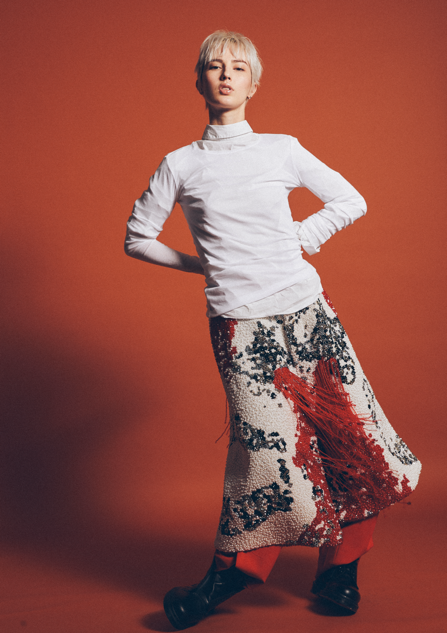 Jaang by FADETOBLACK, editorial fashion photography, image 7: Studio fashion editorial of a model with short platinum hair wearing avant-garde statement pieces, including