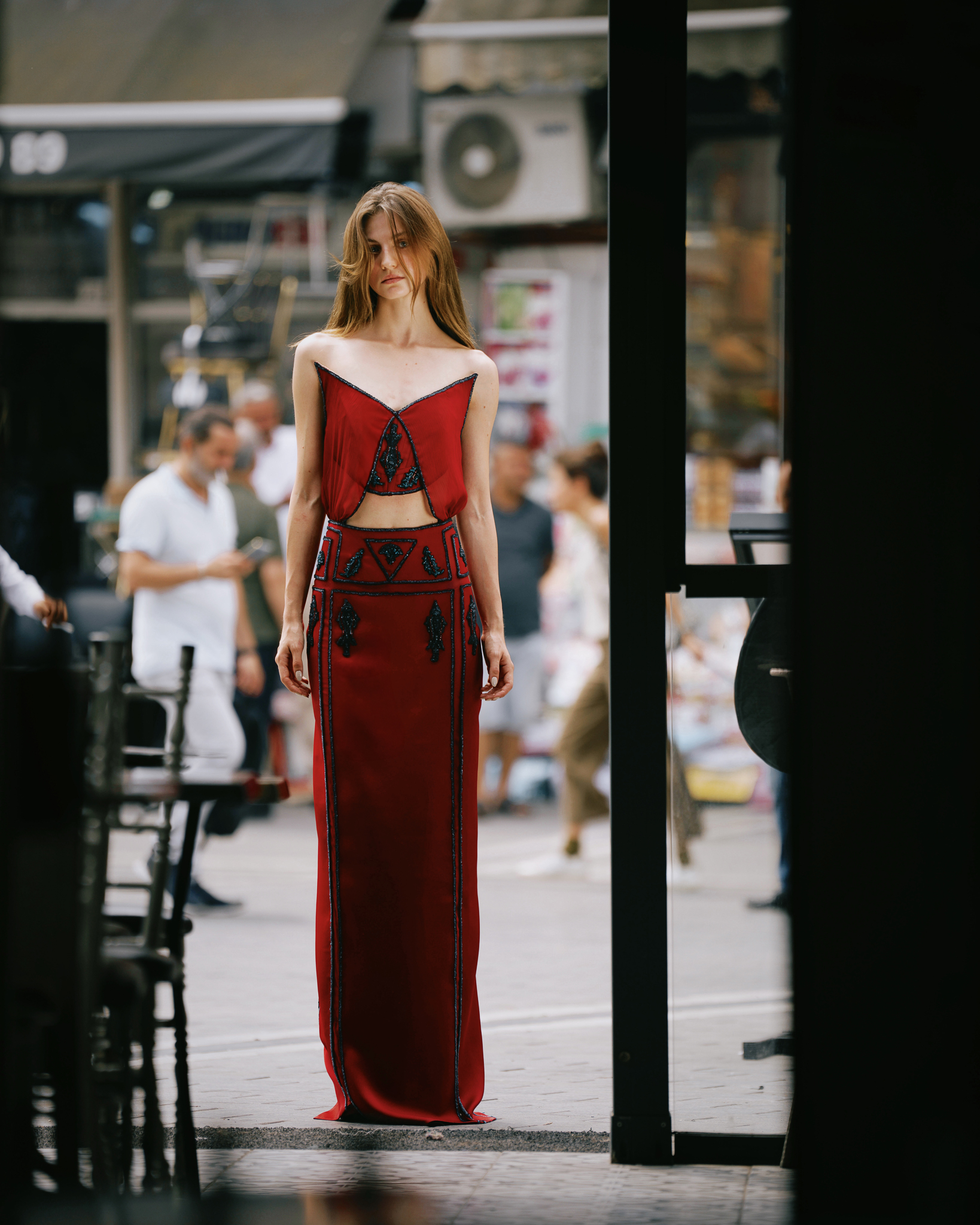 Tayfun Kaba by FADETOBLACK, editorial fashion photography, image 11: Editorial fashion shoot on busy Istanbul streets: models stand motionless in an embroidered dark red gown, a