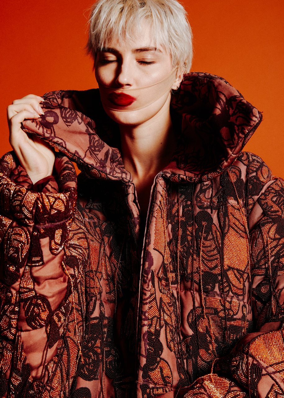 Jaang by FADETOBLACK, editorial fashion photography, image 8: Studio fashion editorial of a model with short platinum hair wearing avant-garde statement pieces, including