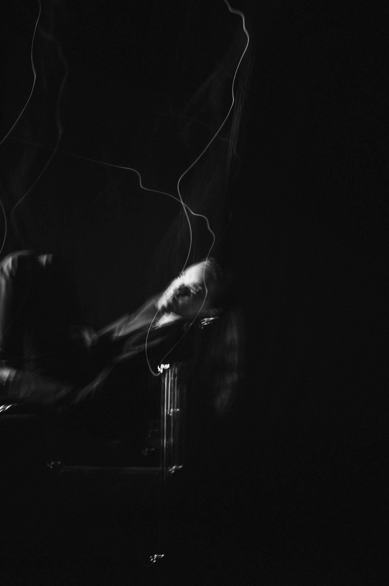 Hanna: The Transformation by FADETOBLACK, fine art portrait photography, image 10: Low-key black and white studio portrait series of a woman in a dark suit posing on and around a chrome-framed