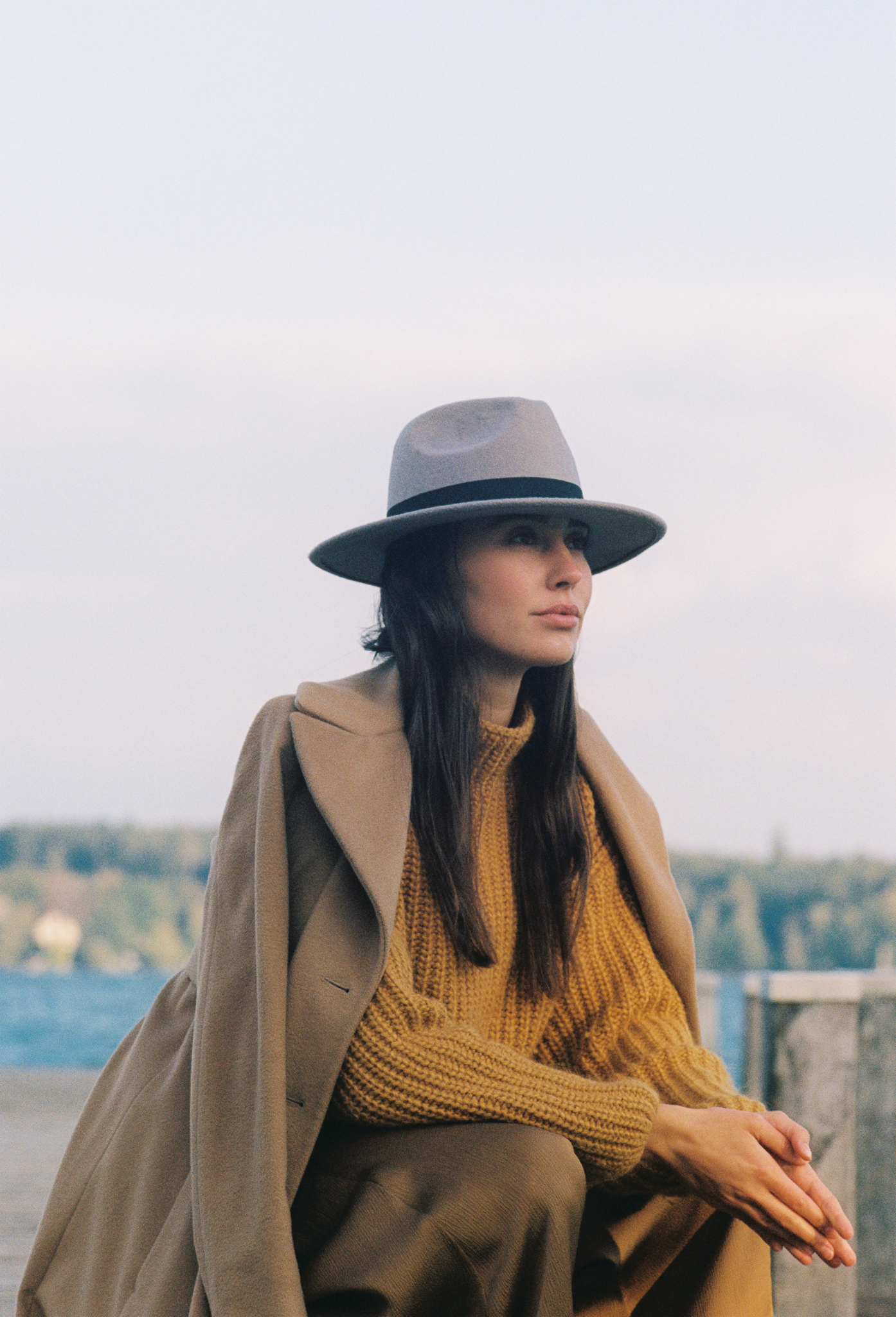 Emily: Autumn Elegance by FADETOBLACK, outdoor portrait photography, image 5: Autumn lakeside portrait series of a young woman with long brown hair wearing a mustard yellow knit and dress