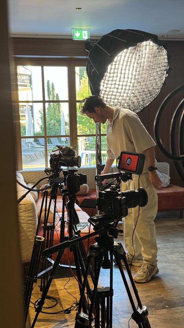 Camera equipment on tripods next to a large softbox and a window, symbolic image for company interview formats, FADETOBLACK Munich