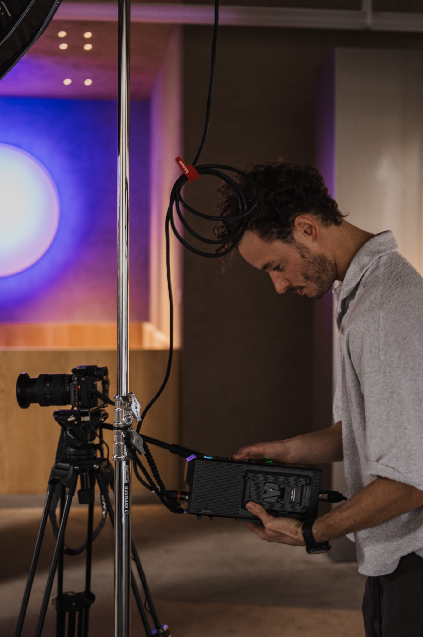 Camera equipment being set up on a tripod in dim indoor lighting, symbolic image for posting times, FADETOBLACK Munich