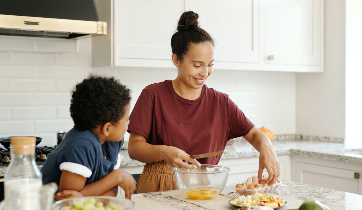 A woman working on a kitchen with a child