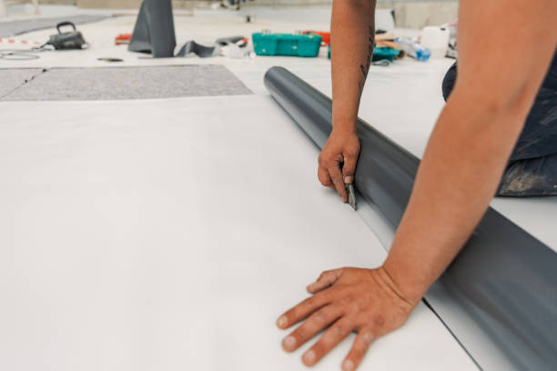 Roofer installing white TPO membrane around rooftop flashing.