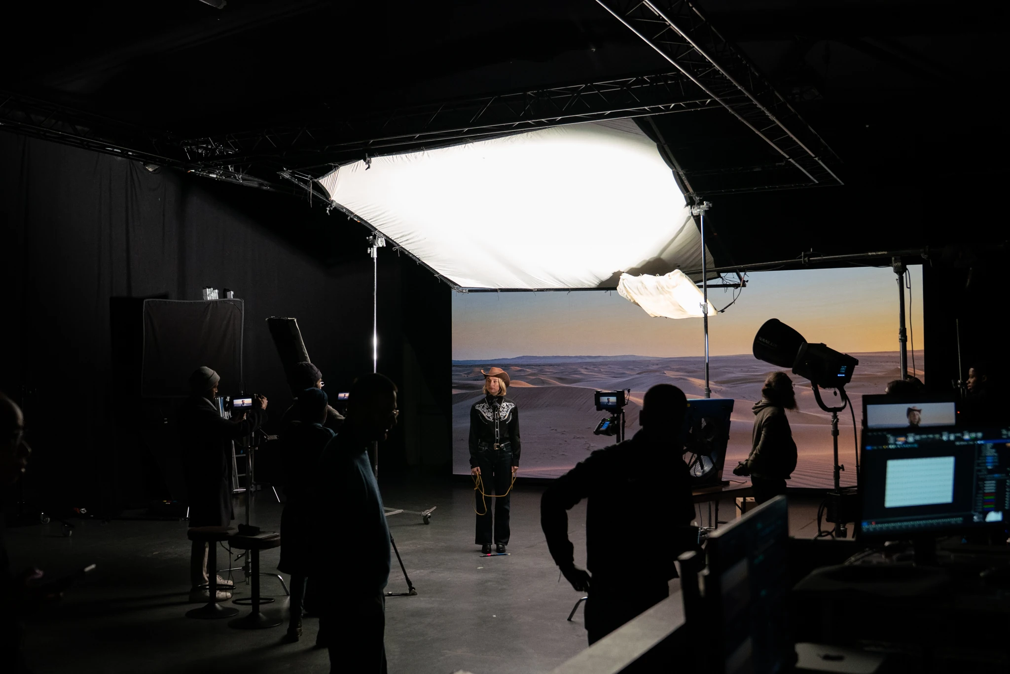 Cast and crew on the Indispensable virtual studio set, with overhead lights and a desert scene on the LED wall.