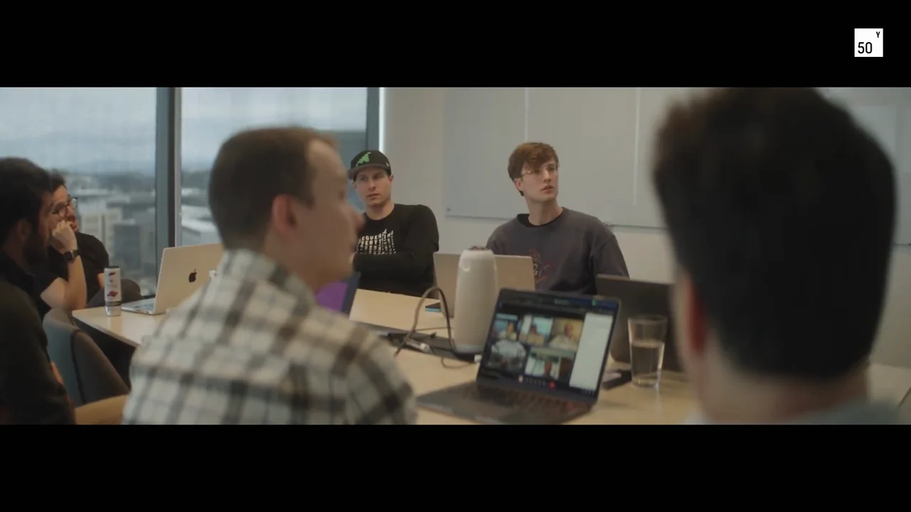 The Plasmidsaurus team gather around a table in their working space.