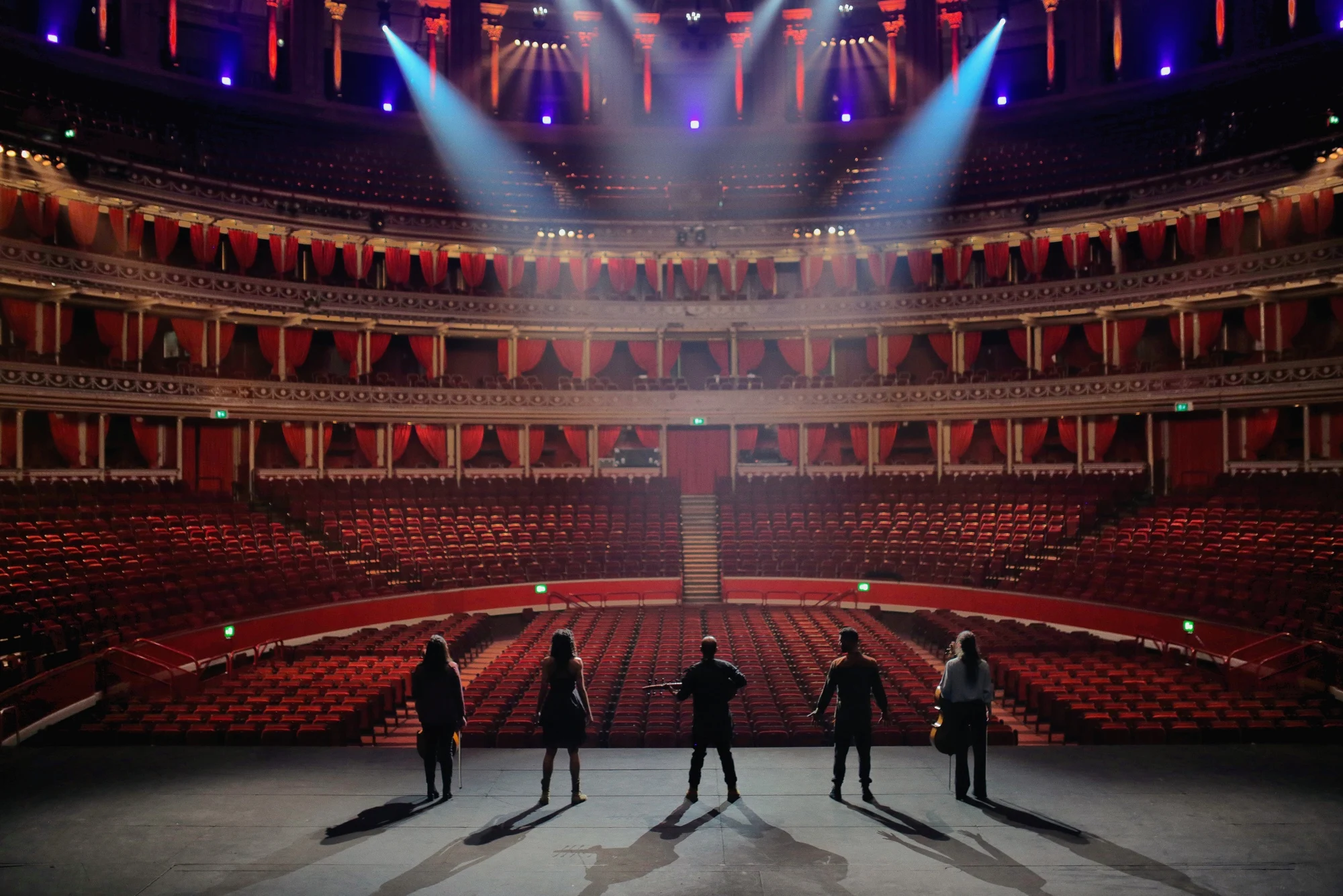 A lone performer in the light of the Royal Albert Hall auditorium.