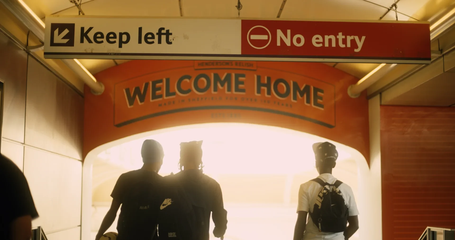 Not Yet - Three friends beneath a Welcome Home sign