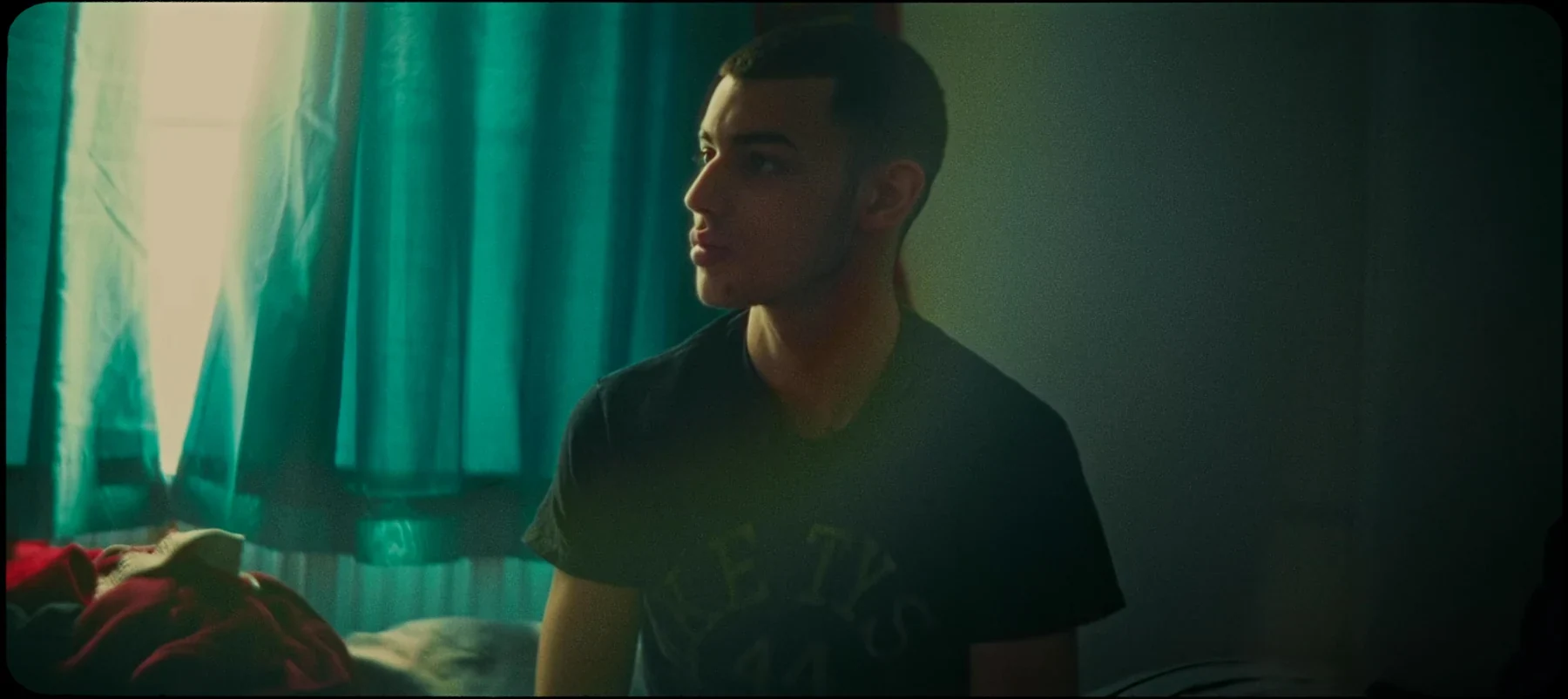 We Move - A portrait beside a teal curtain