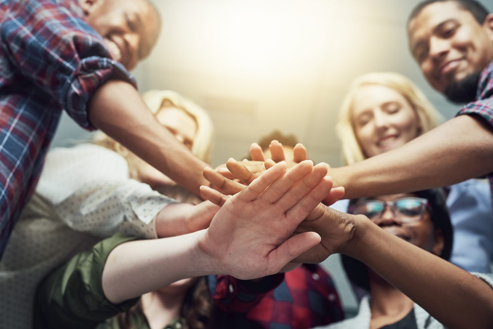 A diverse group of students stacking their hands together