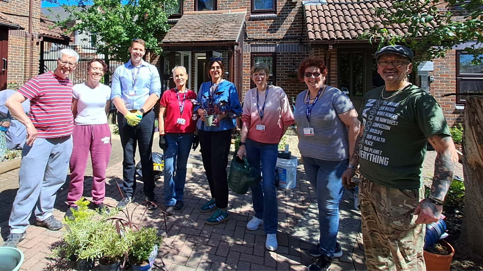 A group of people standing in front of a home smiling