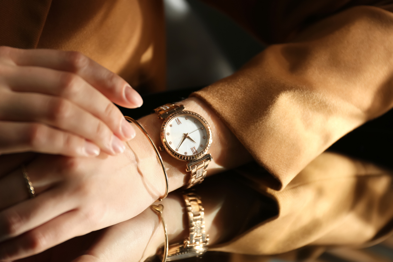 Close up photo of a woman wearing a luxury gold watch