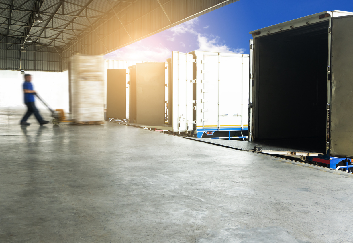 A loading dock with semi-truck trailers lined up to receive outgoing shipments