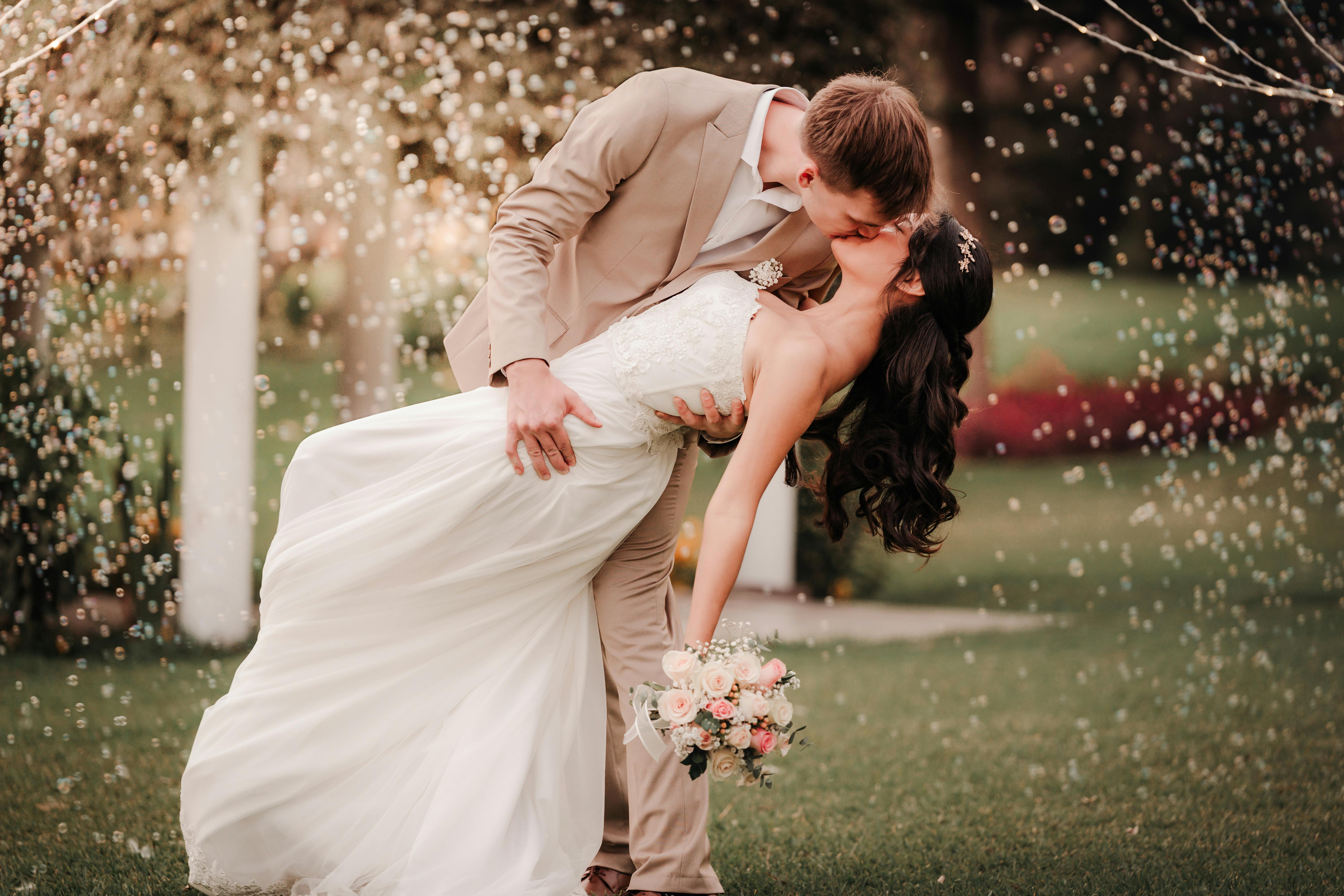 A wedding couple kissing in a field