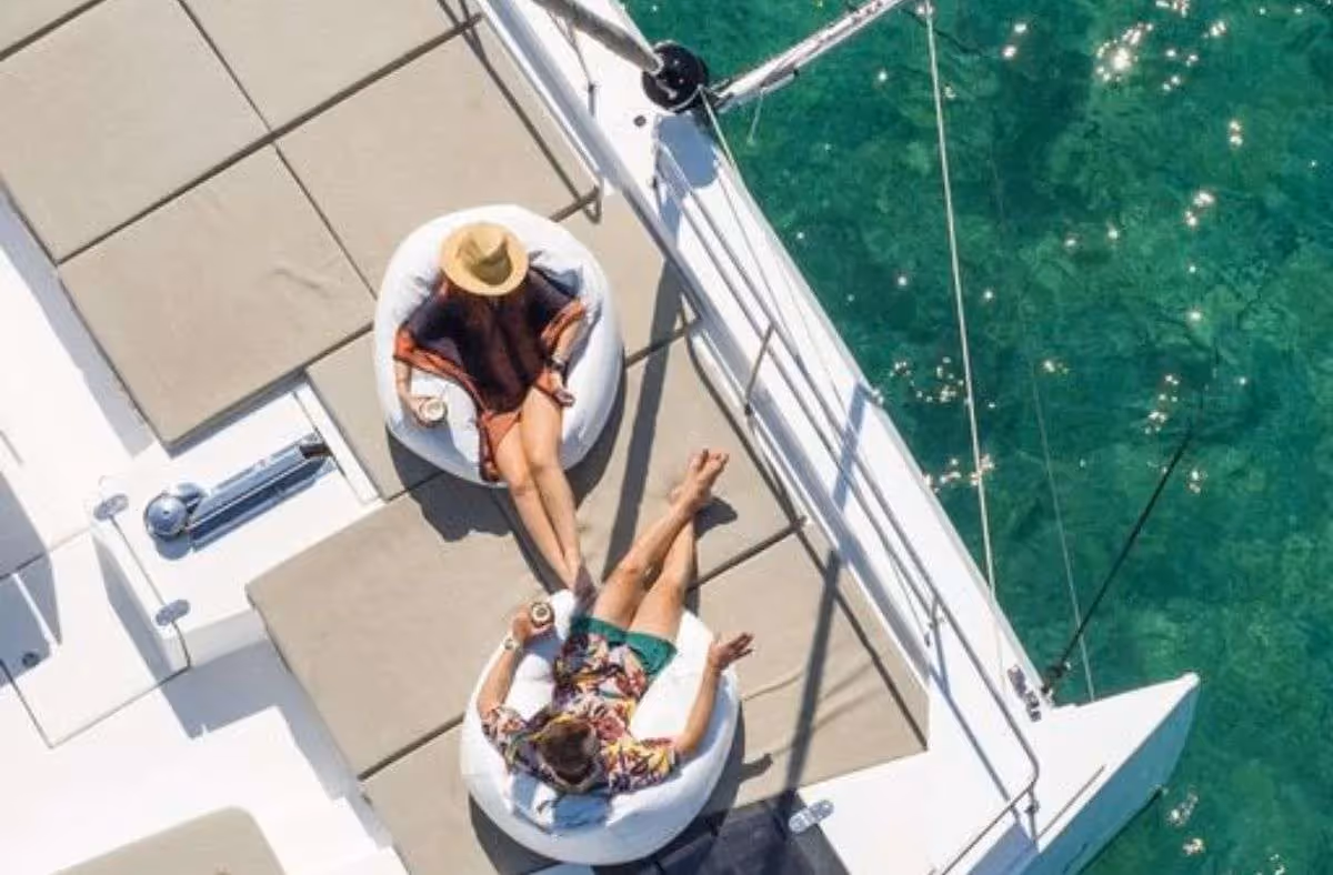 Guests relaxing in the bow hammock seats of a catamaran