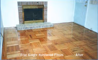 Shiny hardwood floor in a room with a brick fireplace and white walls, labeled 'Blue Knight Hardwood Floors After'.