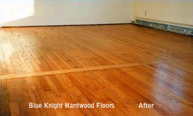 Shiny, newly refinished hardwood floor in a room with baseboard heating along the wall.