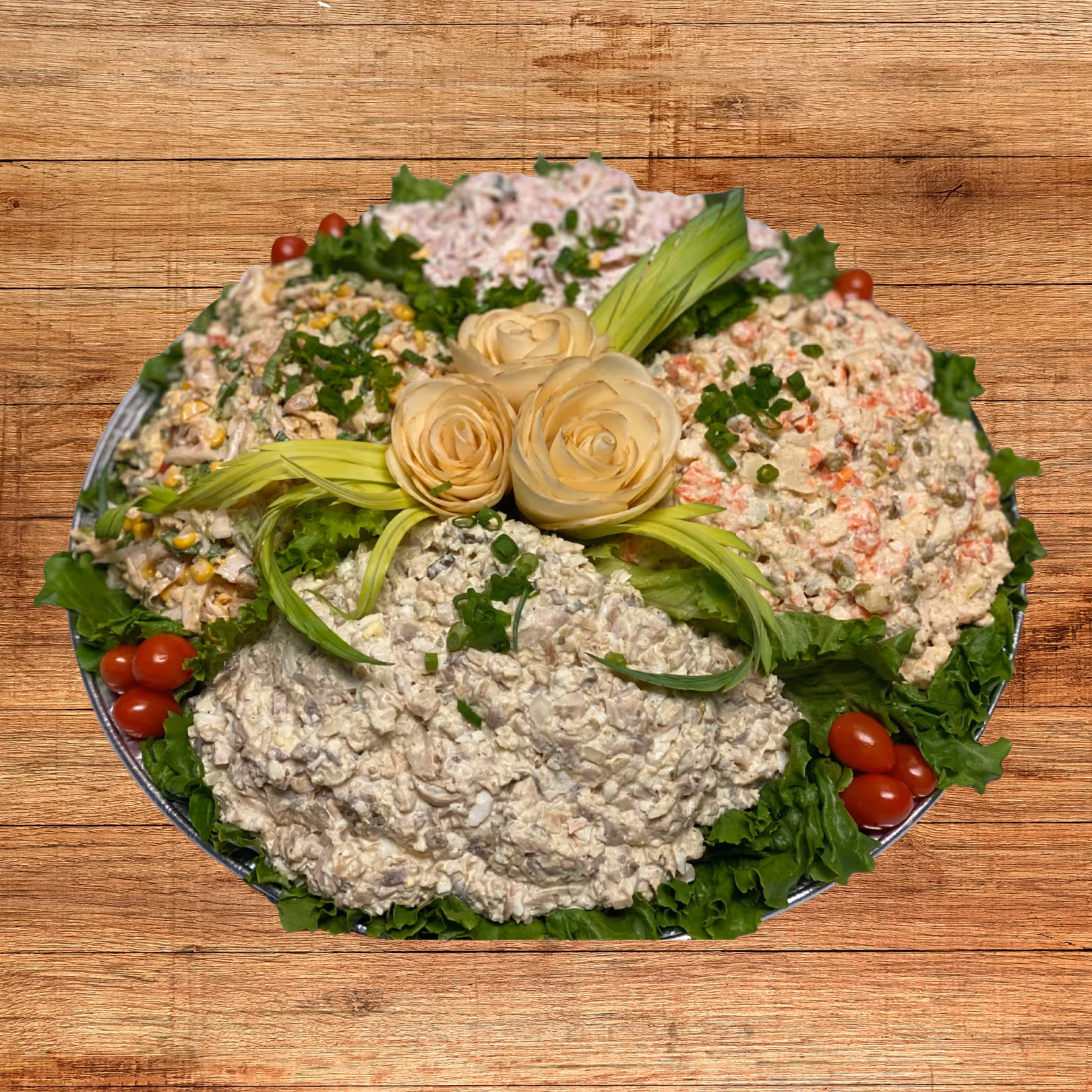 Round platter with various creamy salad mixes garnished with lettuce, cherry tomatoes, chopped green onions, and decorative vegetable carved roses in the center.