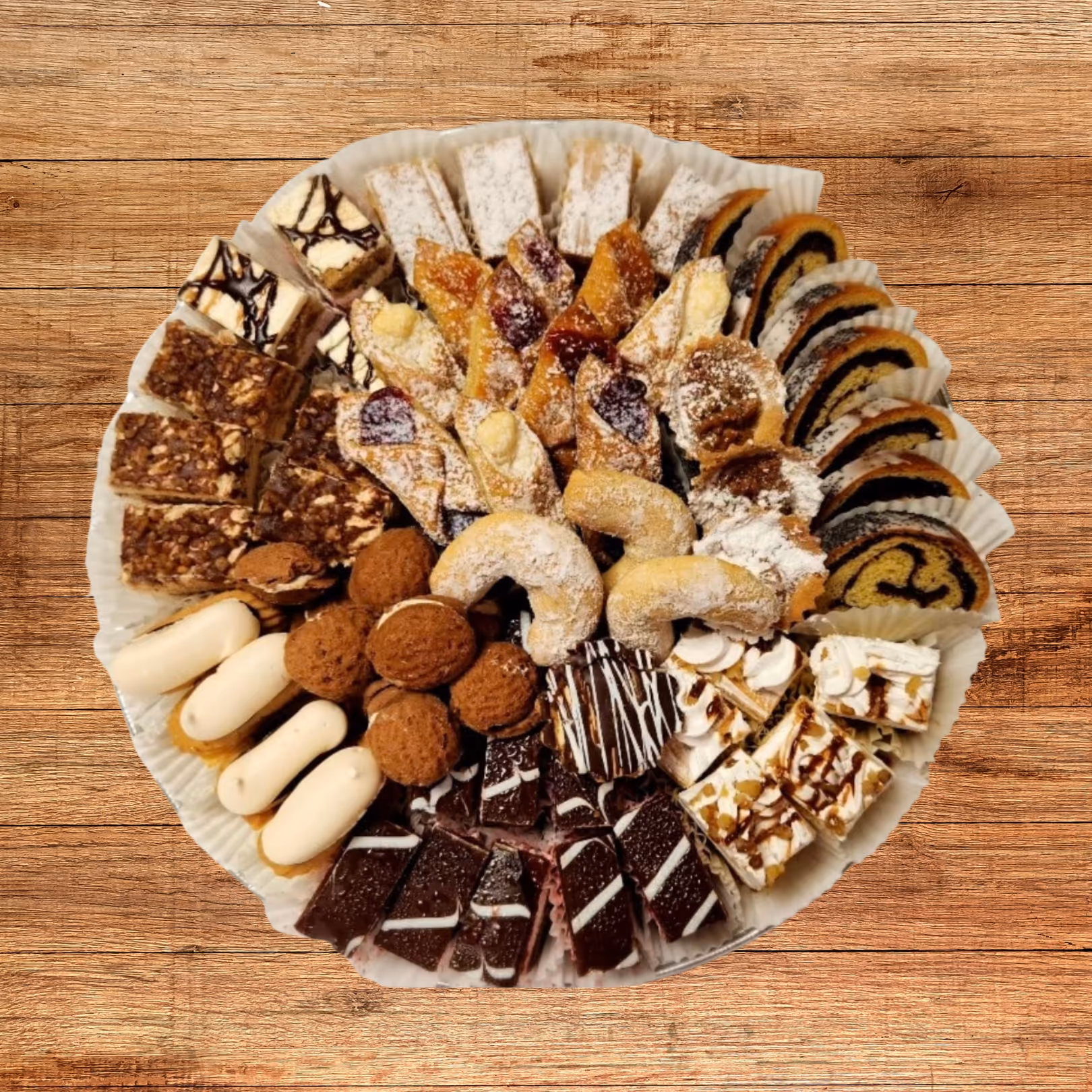 Assorted pastries and cookies arranged on a white round platter on a wooden surface.