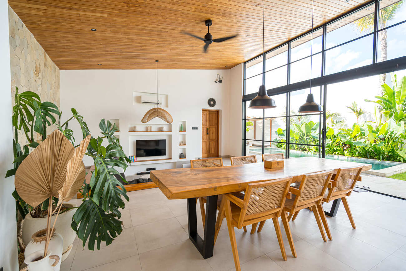 Stylish Bali villa dining room with garden view and natural finishes.