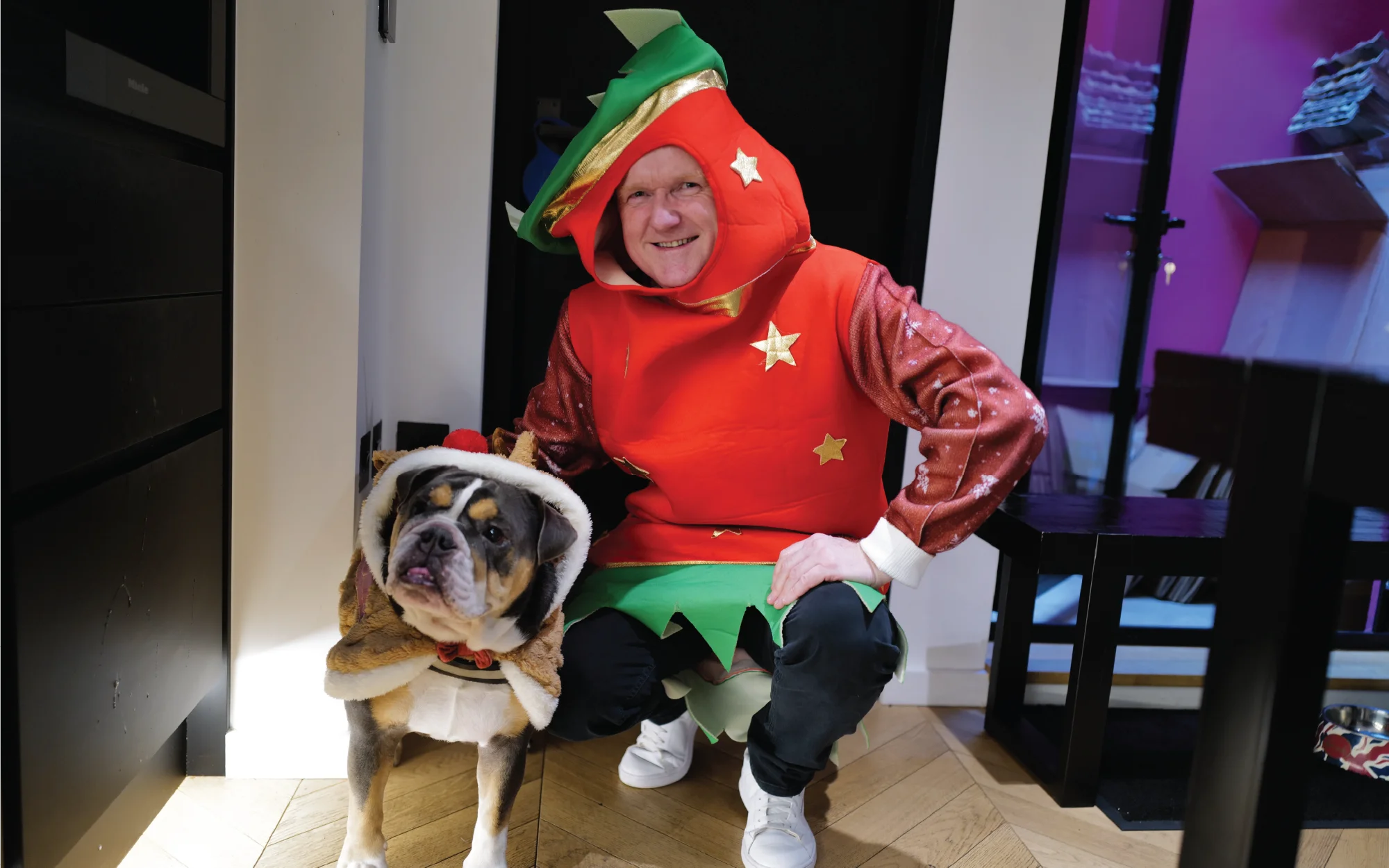 Office Christmas Jumper Day celebration with Secret Santa gift unwrapping, festive costumes, and remote colleagues joining by video.