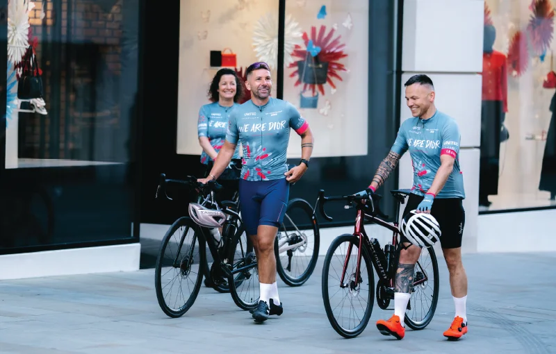Distinct team members in We Are Dior cycling kit outside the Christian Dior flagship store on New Bond Street, London.