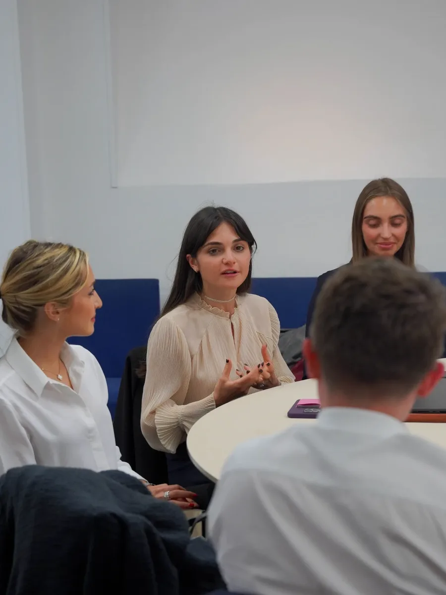 Échanges entre participantes autour d'une table pendant un Promptathon