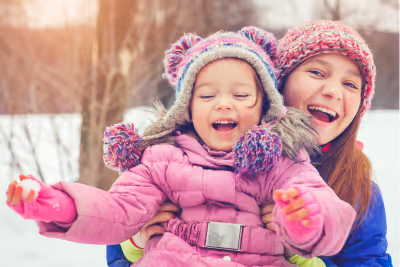Two sisters playing in the snow.