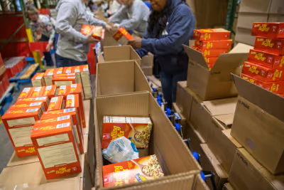 Stuffing mix is packed into God's Pantry Food Bank holiday food boxes.