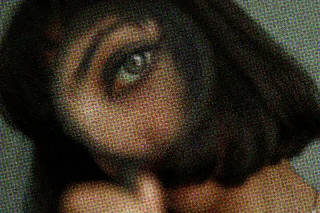 Close up of women holding magnifying glass over her eye